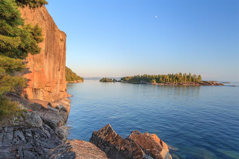 Photo of a rocky cliff along the edge of a lake
