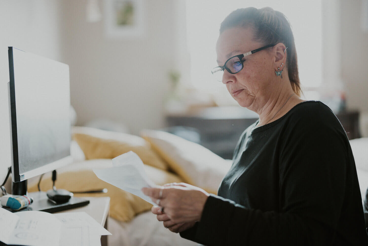 Person looking at documents near a computer