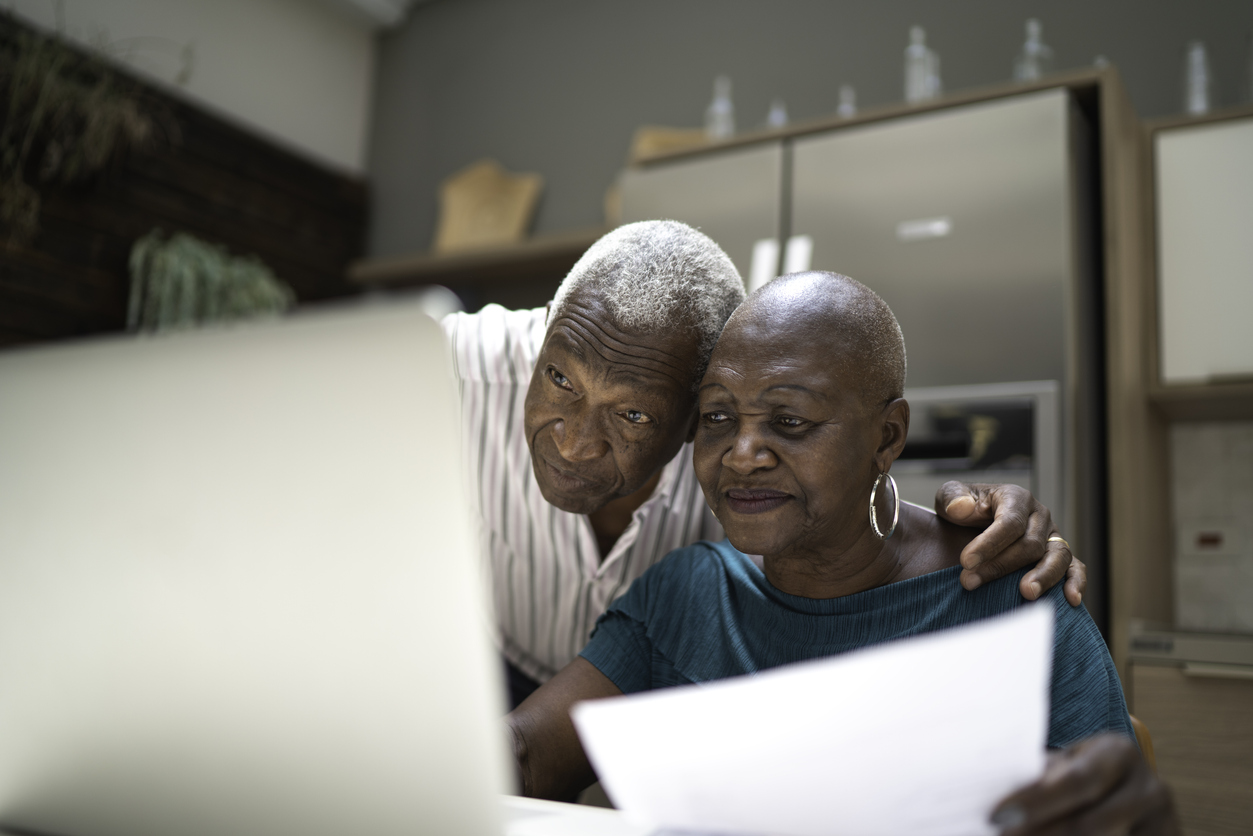Older couple reviewing options on their laptop.