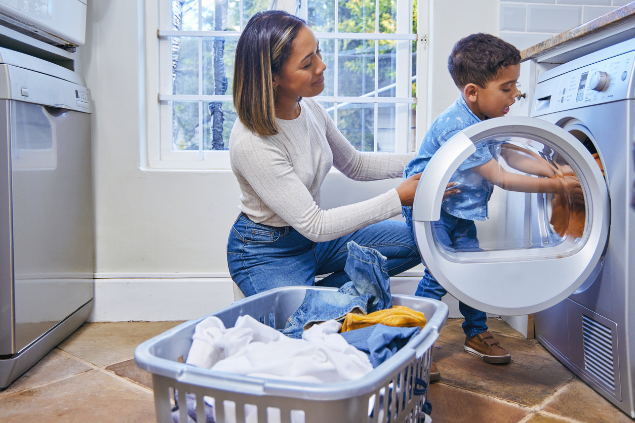 Child helping his mother do laundry.
