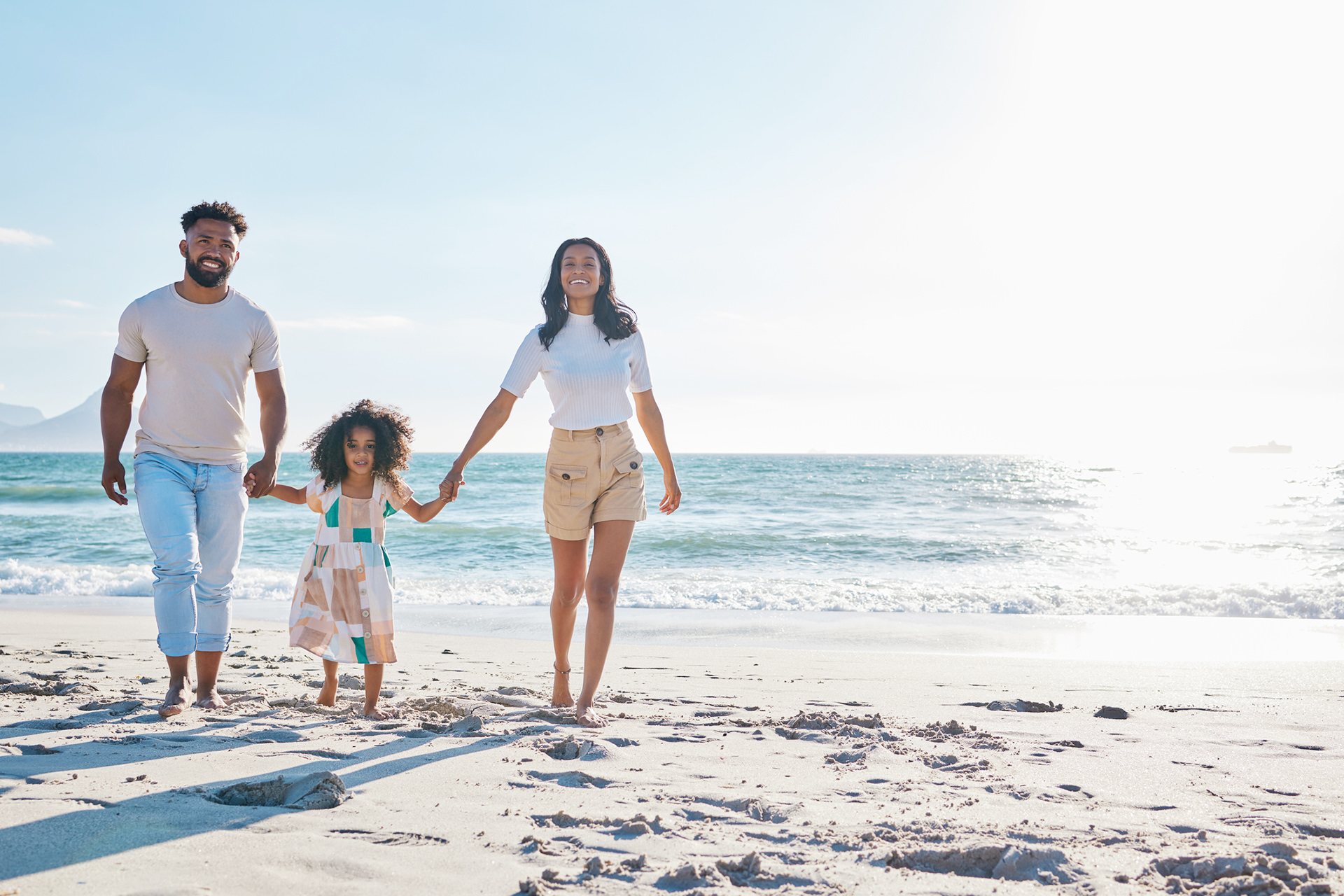 Family walking on a beach together.