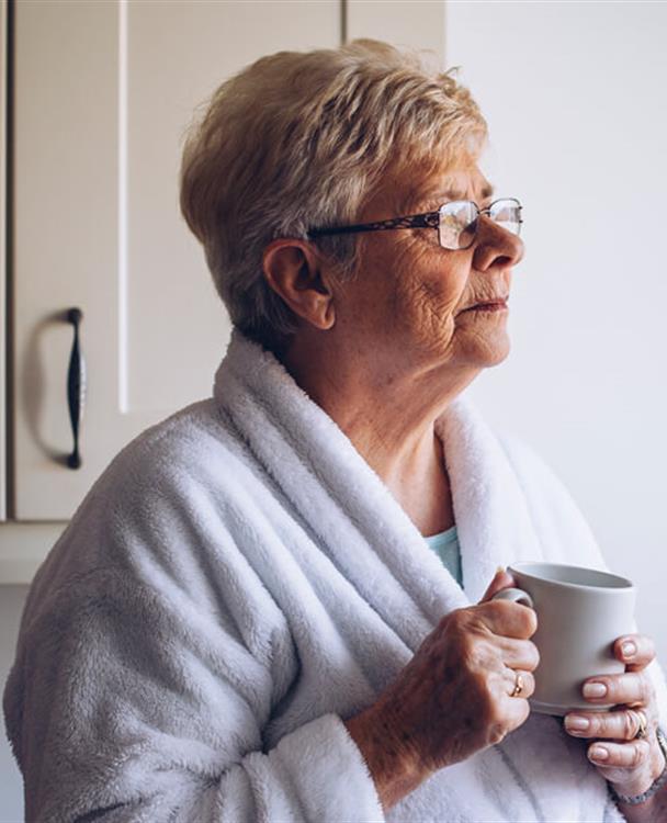 photo of an older woman in a housecoat holding a coffee mug