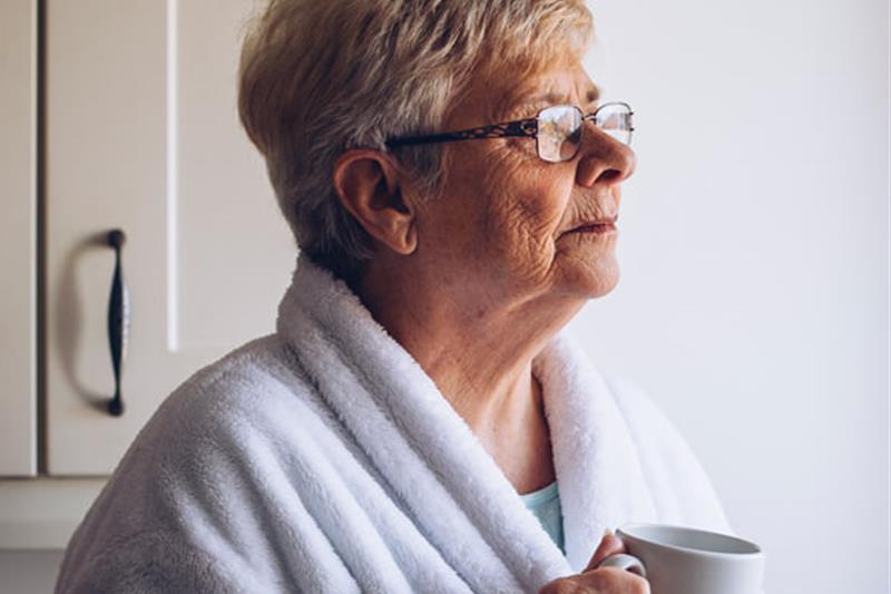 photo of an older woman in a housecoat holding a coffee mug