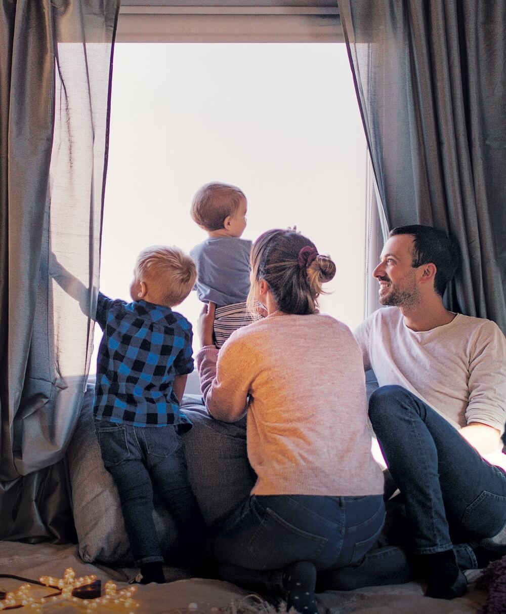 photo of family in front of window during winter