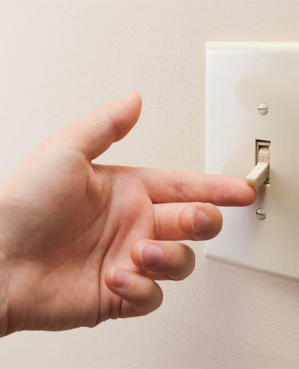 photo of a hand flicking on a light switch