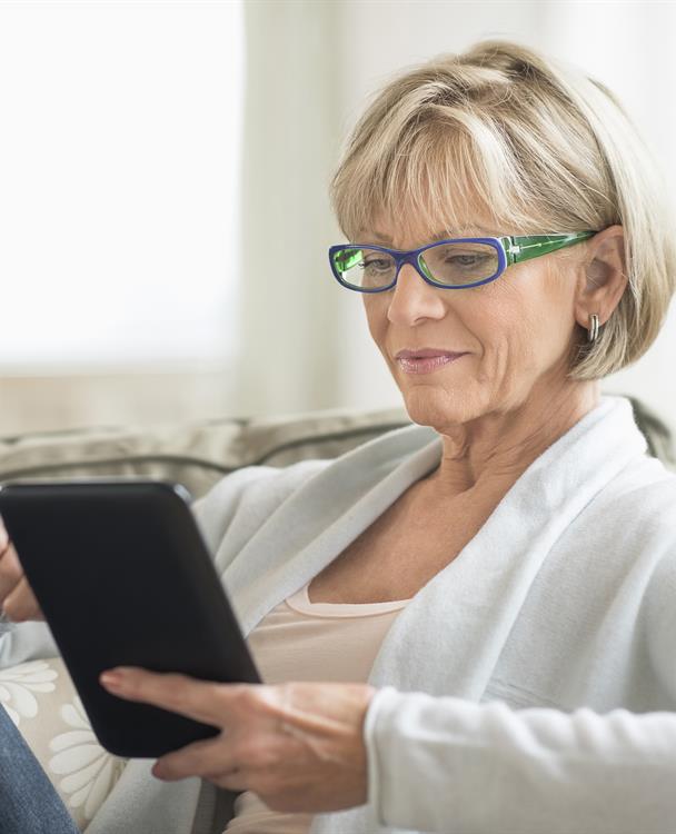 photo of a woman holding a tablet to sign up for outage alerts