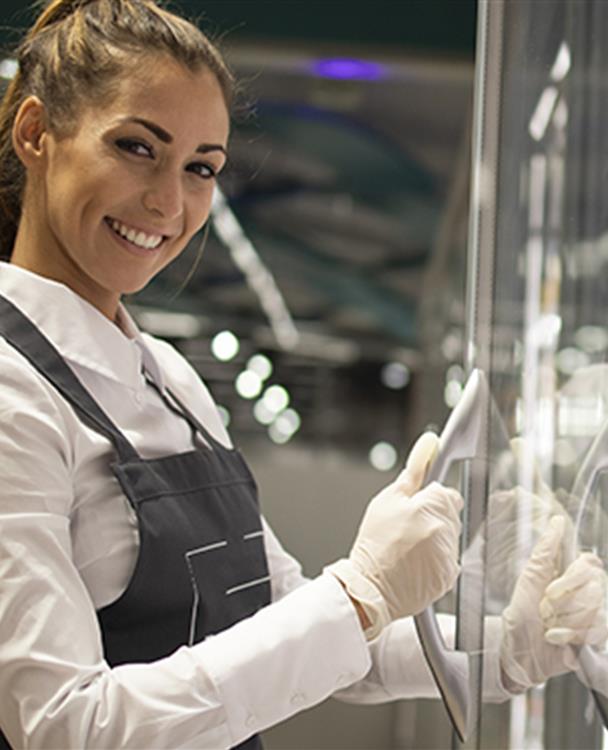 a woman standing in front of a fridge at a grocery store