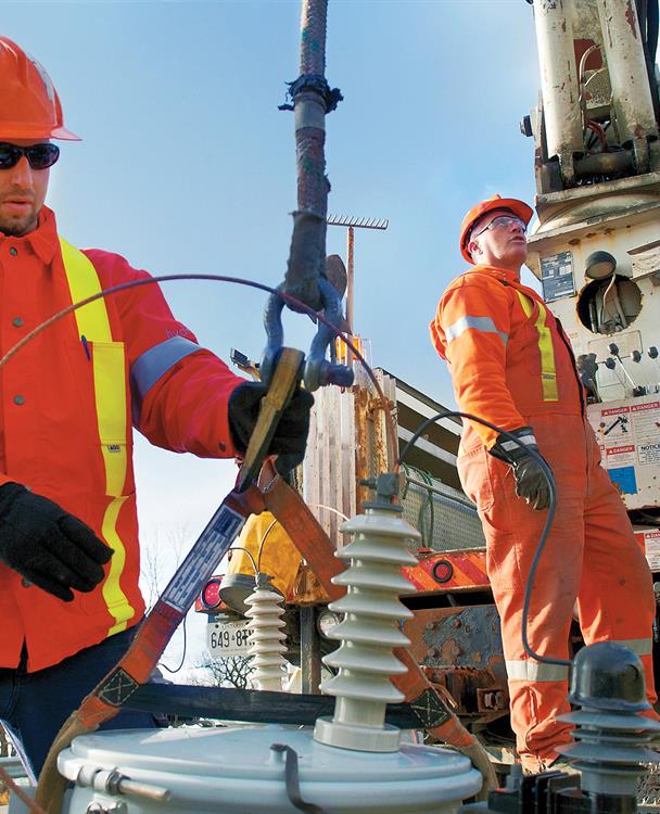 photo of a Hydro One worker holding a spool of wire