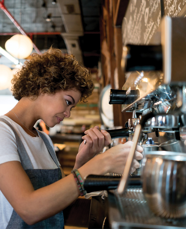 a female barista using an espresso machine