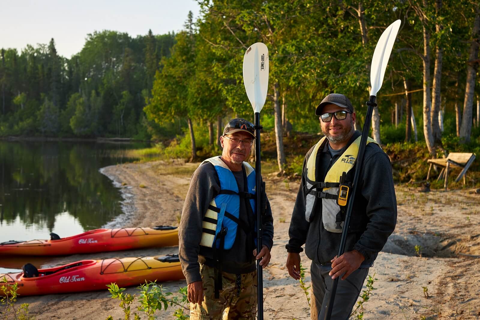 Two men holding kayak oars