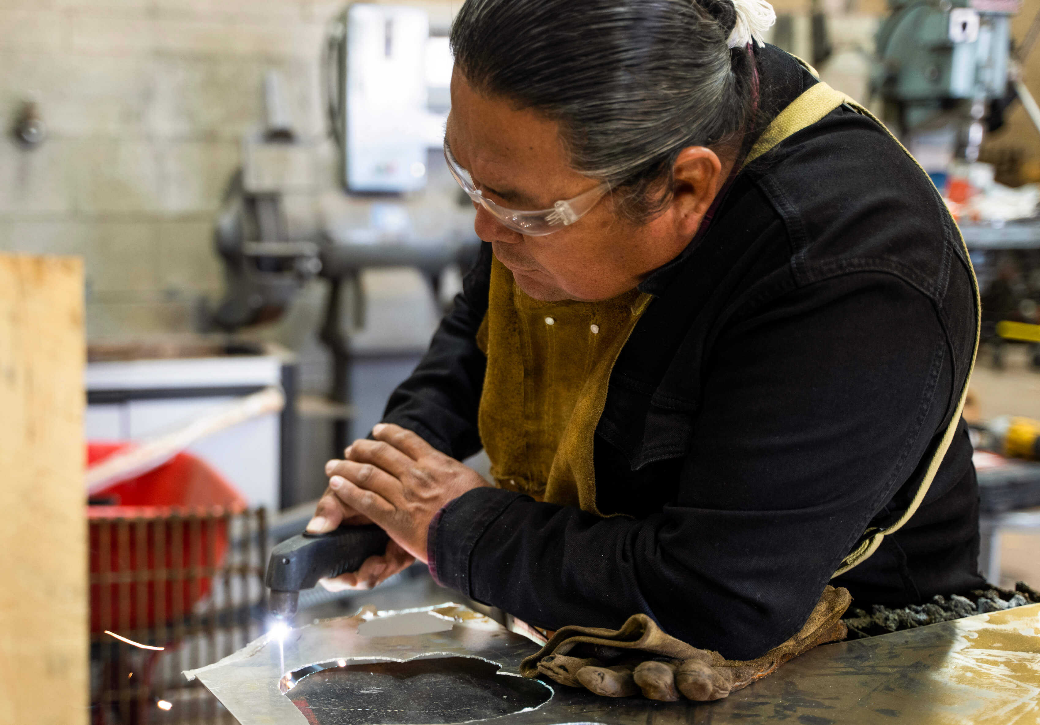 Image of indigenous woman welding